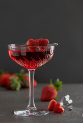 Close up of red drink in crystal glass decorated with two cutted strawberry hearts on a bar skewer. Valentine's Day concept. High quality photo