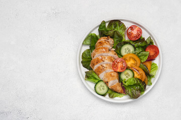 Fototapeta na wymiar Chopped chicken breast with salad. Lettuce, tomatoes, cucumbers with poultry. Healthy eating food on white background