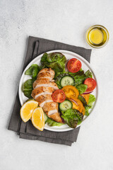 Chopped chicken breast with salad. Lettuce, tomatoes, cucumbers with poultry. Healthy eating food on white background