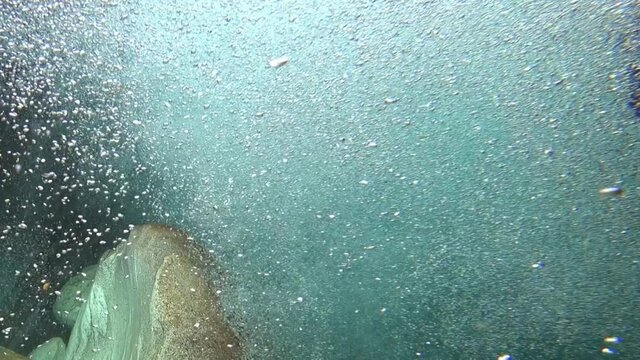 Close-up underwater shooting of steep rapids of mountain river Verzaska in Switzerland. Ecotourism and nature on background of beautiful landscapes. Power of water. River carves canyon.