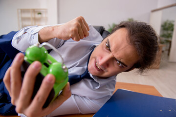 Young male employee sleeping in the office in time management co