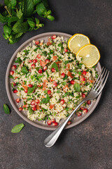 Tabbouleh salad with couscous, tomato, mint, parsley and pomegranate seeds. Traditional Middle Eastern cuisine 