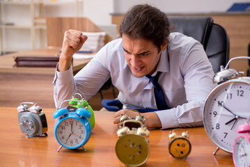 Young male employee sleeping in the office in time management co