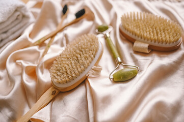 Zero waste bathroom accessories flat lay wooden desk background, spa body care concept. Natural sisal body brushes dry massage quartz facial roller, black bamboo toothbrushes. Eco-friendly lifestyle.