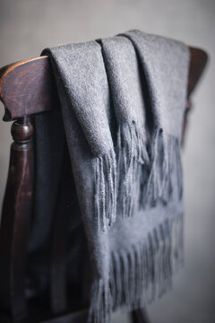 Close-up of gray blanket on chair's backrest at home