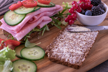 Healthy breakfast sandwich with a bowl full of berries