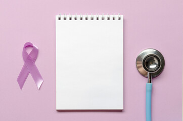 Notebook with purple awareness ribbon on a purple background. Copy space. World epilepsy awareness...