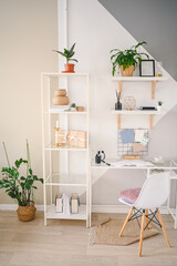 Background image of empty home office working space in a cozy apartment with modern scandinavian design. White table chair shelving with stylish decor elements, stationery, houseplants in wicker pots.