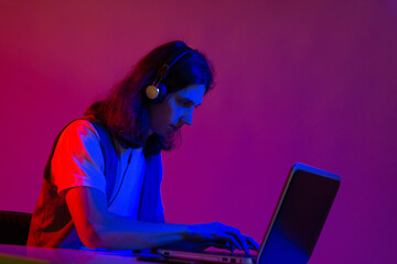 Online programming training, computer programmer or student. A young man with long hair and...