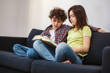 Girl and boy reading book on white background
