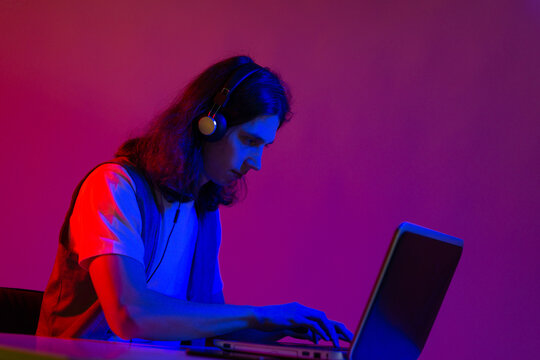 Online programming training, computer programmer or student. A young man with long hair and headphones.