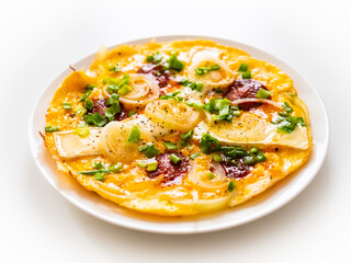 Delicious breakfast - scrambled eggs with onion, camembert and chorizo on wooden table
