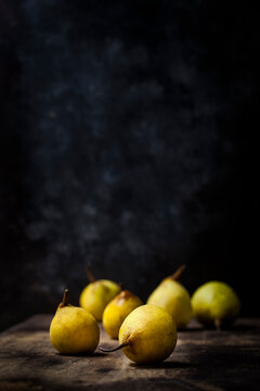 Close-up of pears on wooden table against wall