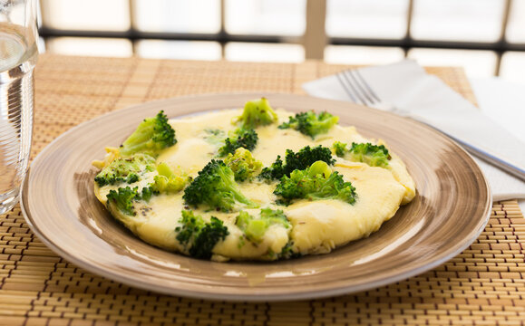 wholesome breakfast. omelet with broccoli on brown plate