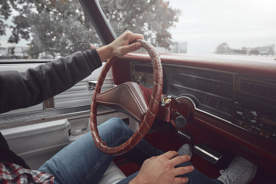 Man in retro clothes driving vintage American car.