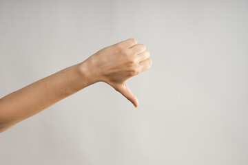 Hand gestures. Thumbs down, dislike disapproval. women's hand