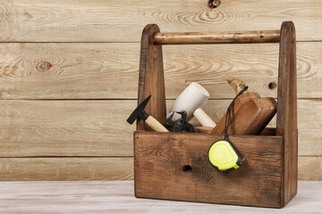 wooden box of carpenter tools, hammer, mallet, tape, 
measure pliers
plane