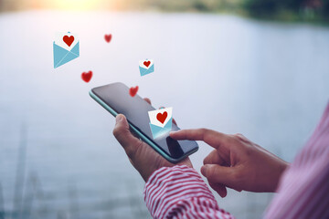 Hand typing love letter email in smartphone social network online community  with social media love...
