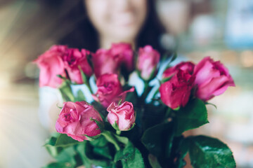 Woman happy hold pink roses recieve from someone in love on Valentine's day.