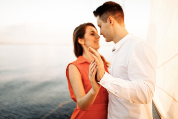 Tender hugs of a young couple in love, hands in the foreground, blurred background.