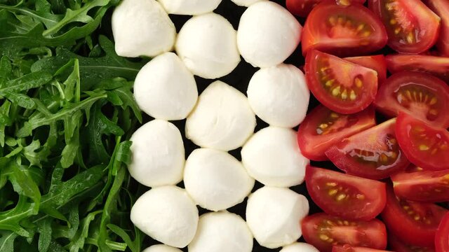 fresh caprese salad with mozzarella cheese, tomatoes and arugula top view. Healthy food and vegetarian concept.