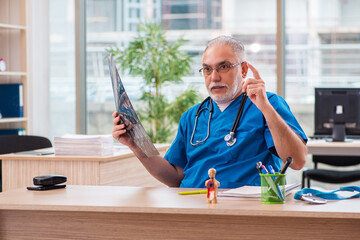 Old male doctor radiologist working in the clinic