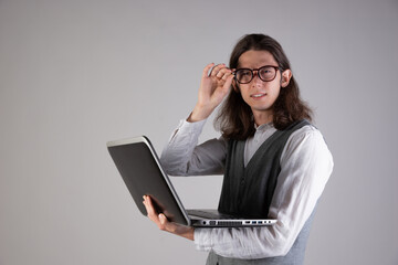 Training and new technologies, online courses, e-learning. A young man with long hair and glasses.