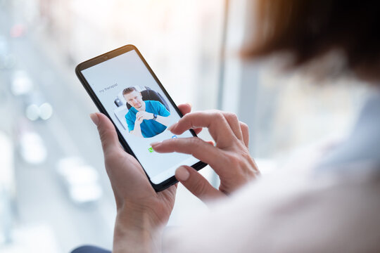 Woman holding smartphone with therapist contact