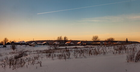 Naklejka premium Winter sunset on the background of the village