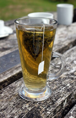 Green tea in a tall glass on a wooden table