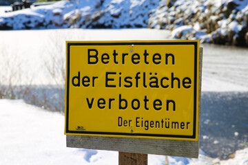 Viersen, Germany - February 9. 2021): View on yellow german sign do not enter sheet of ice with frozen lake background