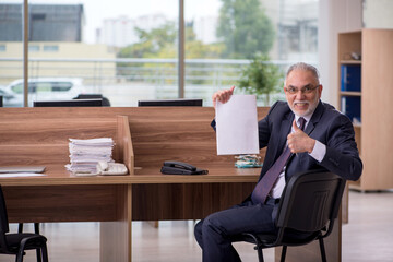 Old male employee sitting in the office