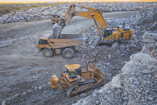 Mining machinery working over rocks from aerial view