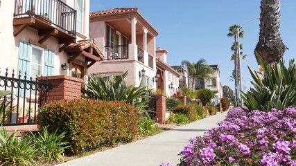 Houses on suburban street in California USA, Oceanside. Generic buildings in residential district near Los Angeles. Real estate property exterior. Tropical gardens, palms near typical american homes.