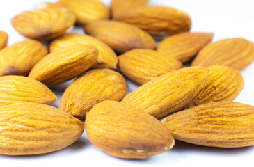 Fototapeta premium Almond nuts lying on white background. Healthy sport food. Vegan concept. Close up.
