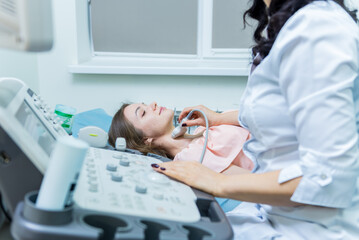 Doctor using ultrasound scanning machine for examining a thyroid of woman