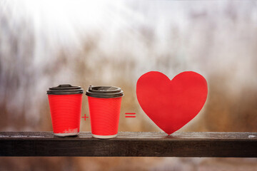 Close up red paper cup with coffee, heart shape on natural blurred background. Love and Valentines...