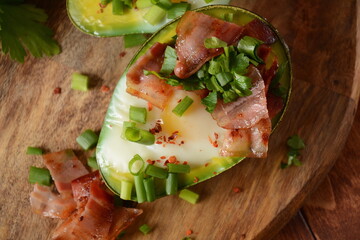 Baked avocado and eggs boats with bacon crumbles . Low carb high fat breakfast
