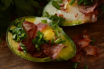 Baked avocado and eggs boats with bacon crumbles . Low carb high fat breakfast