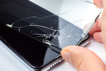 Man replacing the broken tempered glass screen protector for smartphone. Close up.