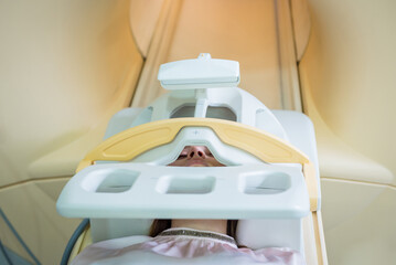 Radiologist prepares the young woman for an MRI brain examination