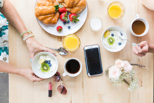 Overhead View Of Friends Having Breakfast At Table In Cafe