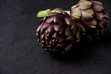Fototapeta premium fresh artichokes close-up on dark gray background