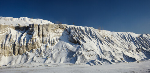 Beautiful texture of the slope of the hill of small stone fractions, covered with snow against a...