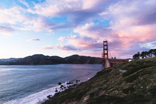 Golden Gate Bridge over sea against cloudy sky at Yosemite National Park during sunset