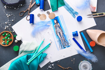 Fashion designer workplace with sketches on dark background