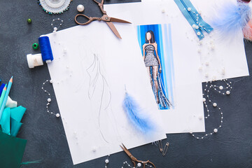 Fashion designer workplace with sketches on dark background