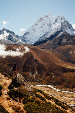 Rear view of male hiker standing on rock against blue sky at Sagarmatha National Park during sunny day