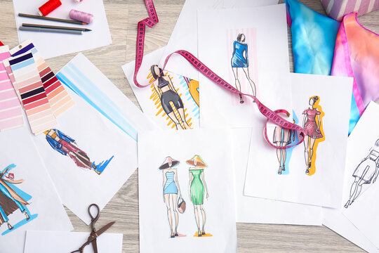 Female fashion designer working with sketches on floor in studio