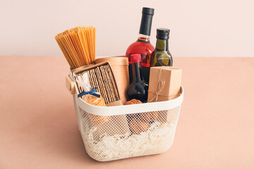 Gift basket with products on color background